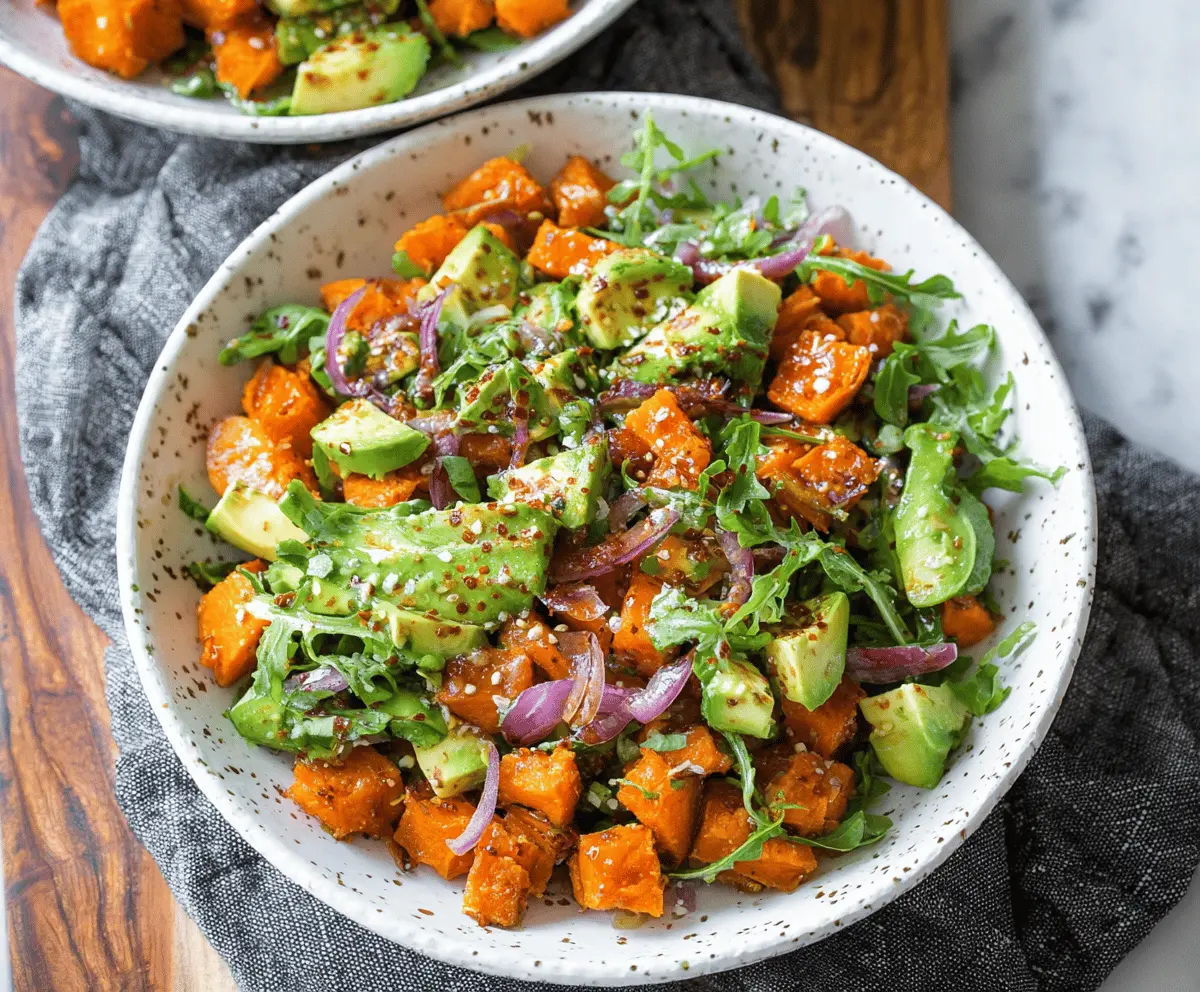 Creamy sweet potato salad with fresh avocado and herbs, served in a bowl, perfect for a healthy meal or side dish.