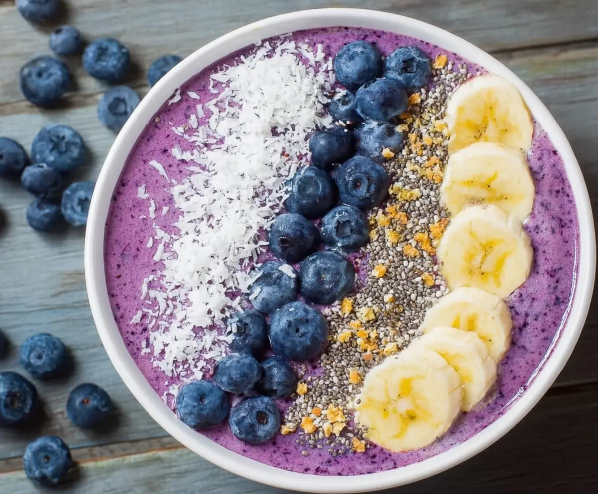Healthy blueberry smoothie bowl topped with fresh blueberries, granola, and honey for a colorful breakfast