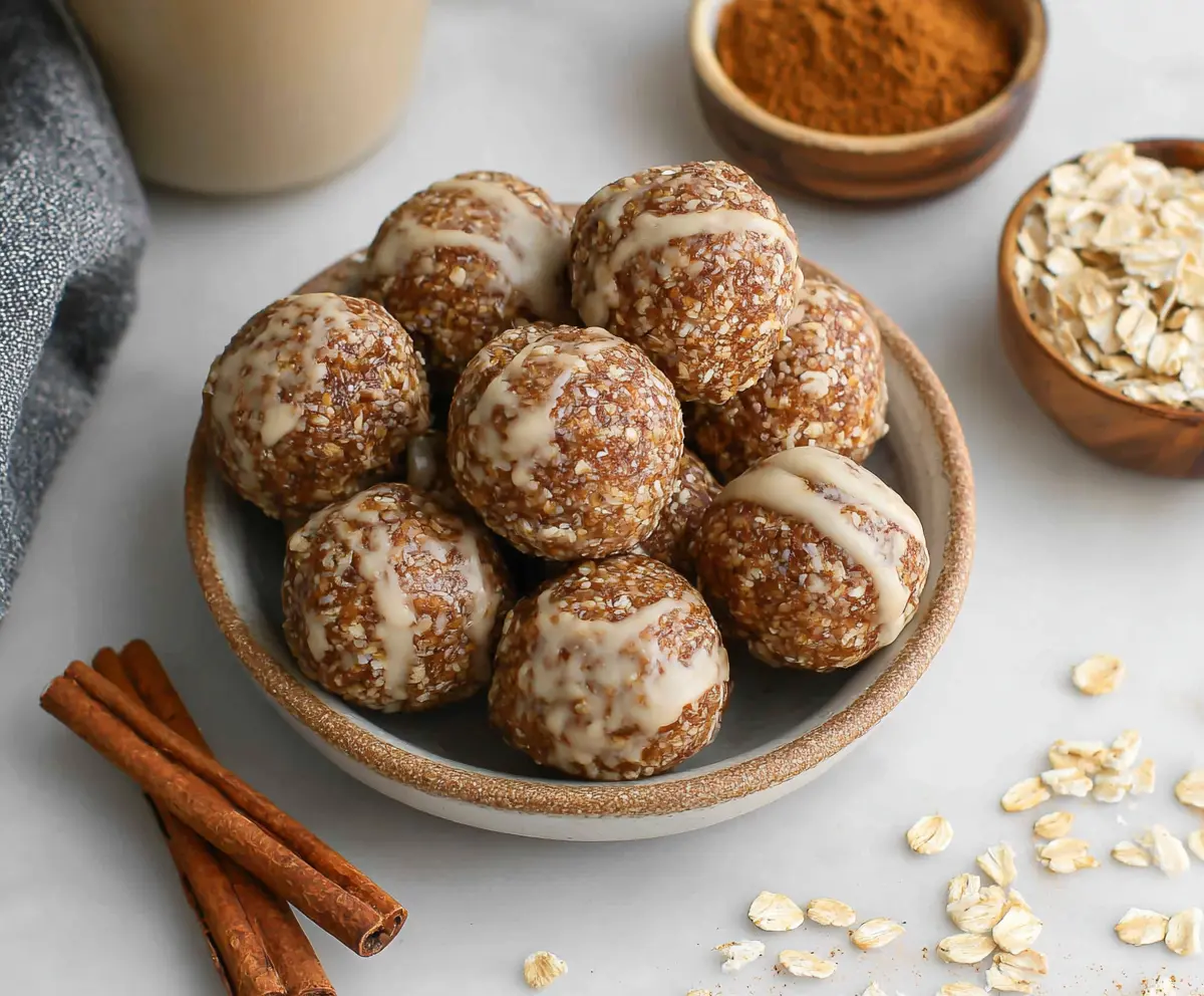Close-up of Cinnamon Roll Energy Bites on a ceramic plate, showcasing their golden-brown exterior and cinnamon swirl filling.
