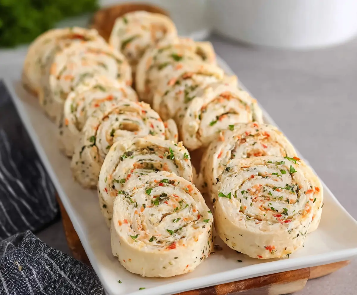 Delicious cream cheese pinwheels with flaky pastry and savory filling on a wooden platter