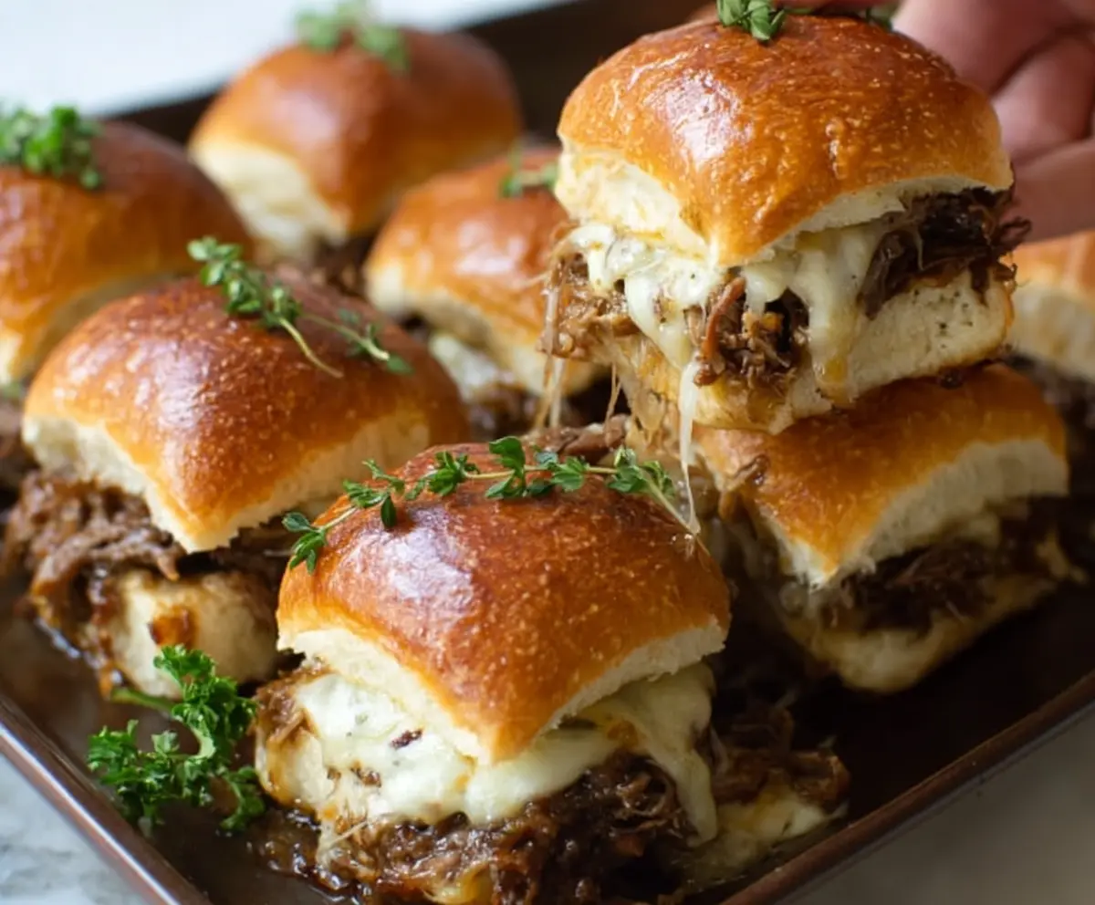 Delicious French Onion Beef Sliders with melted cheese and caramelized onions on a slider bun.
