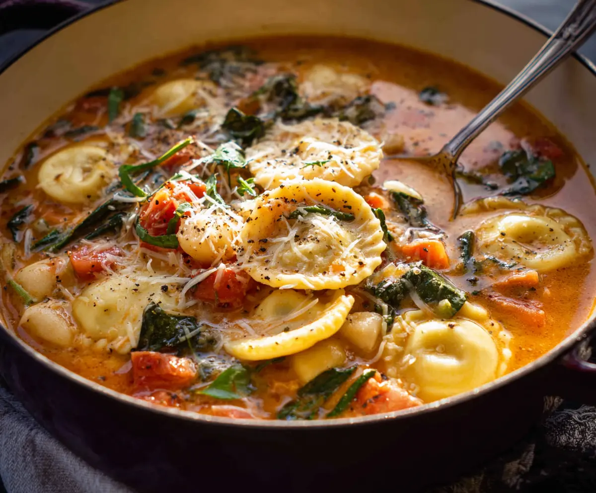 Delicious Tuscan Ravioli Soup with fresh herbs and hearty ingredients in a bowl.