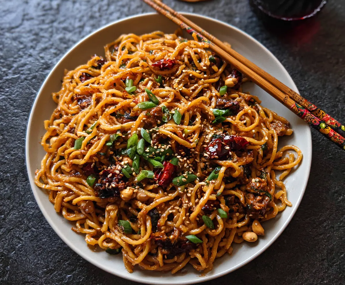 Delicious spicy sesame noodles garnished with sesame seeds and scallions
